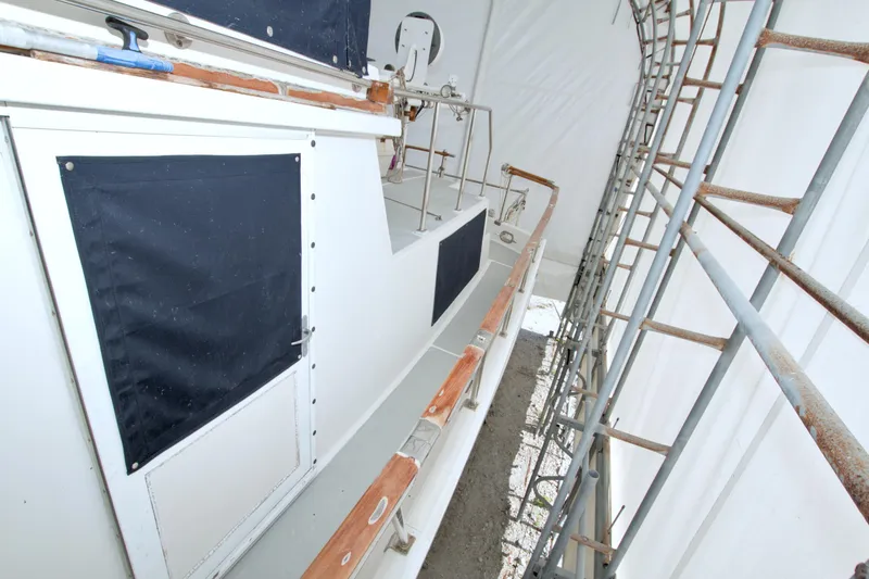 Slide: The Image of 1999 Monk 36 Trawler under protective cover with visible scaffolding. - 16