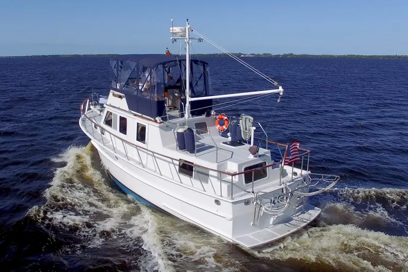 Slide: The Image of 1999 Monk 36 Trawler cruising on open water under clear blue skies. - 2
