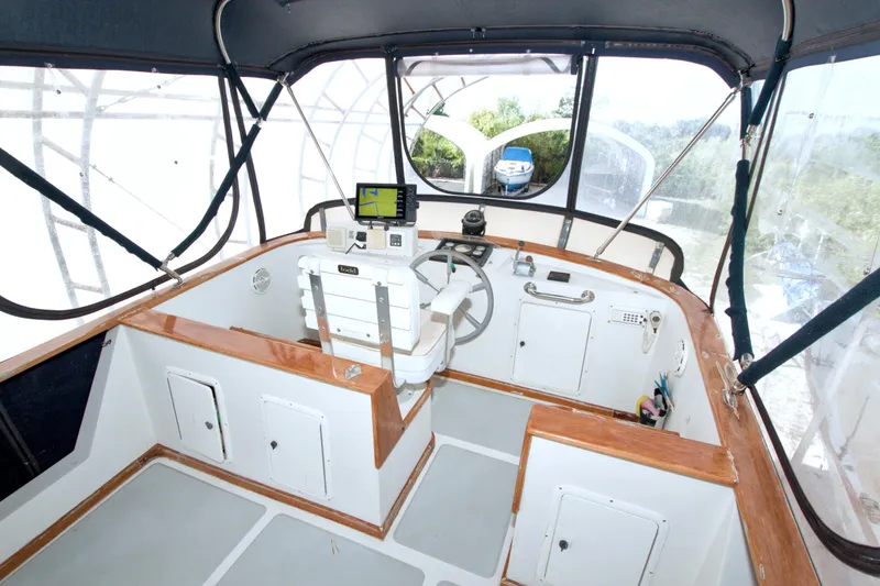 Slide: The Image of 1999 Monk 36 Trawler helm with steering wheel, navigation equipment, and enclosed cockpit. - 21