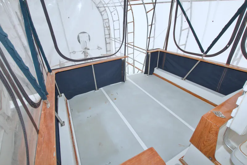 Slide: The Image of Enclosed deck area of a 1999 Monk 36 Trawler with wooden trim and clear panels. - 27