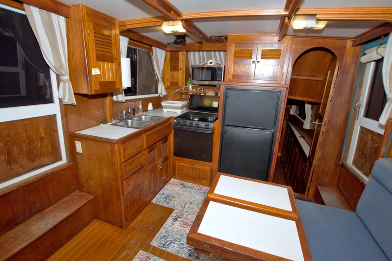 Slide: The Image of Interior of 1999 Monk 36 Trawler with wooden cabinetry and compact kitchen area. - 29