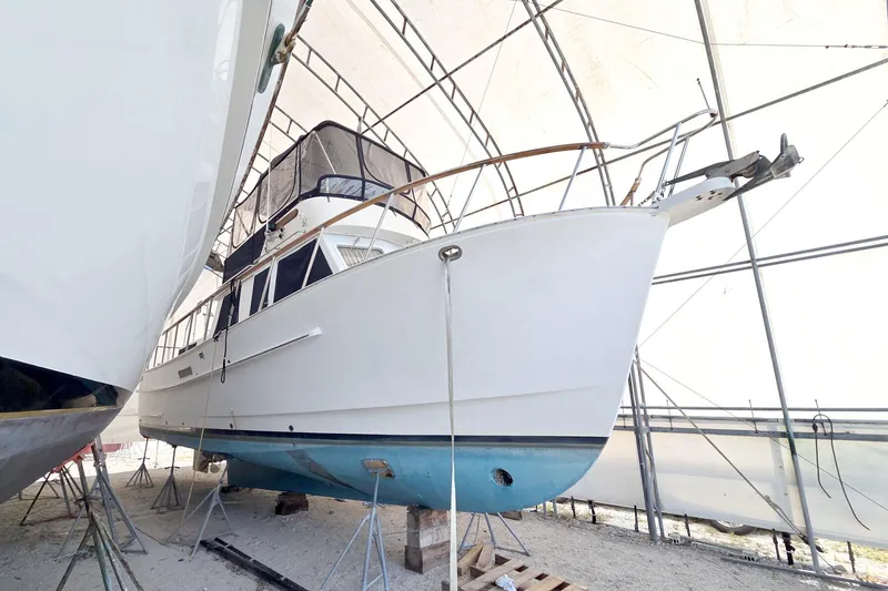 Slide: The Image of 1999 Monk 36 Trawler in dry dock, covered and supported by stands. - 3