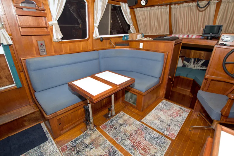 Slide: The Image of Cozy interior of 1999 Monk 36 Trawler with blue seating and wooden accents. - 31