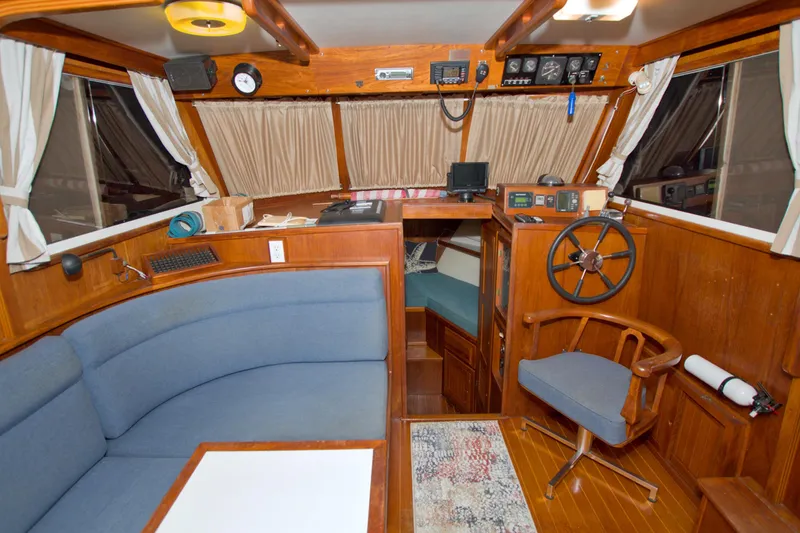 Slide: The Image of Interior of a 1999 Monk 36 Trawler with wooden helm and seating area. - 32