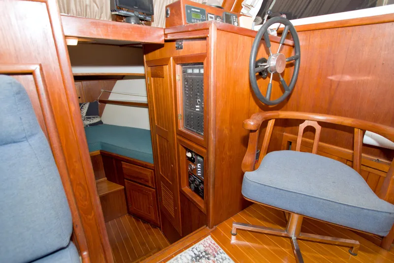 Slide: The Image of Interior of 1999 Monk 36 Trawler with wooden helm, seating, and cabin area. - 36