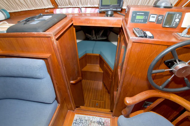 Slide: The Image of Interior of a 1999 Monk 36 Trawler with wooden helm and seating area. - 37