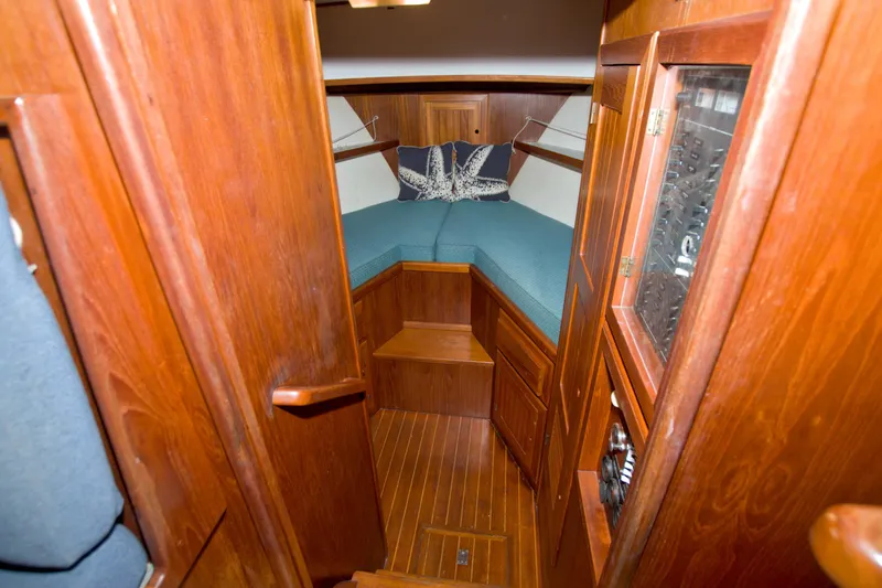 Slide: The Image of Cozy cabin interior of 1999 Monk 36 Trawler with wooden finish and teal cushions. - 38