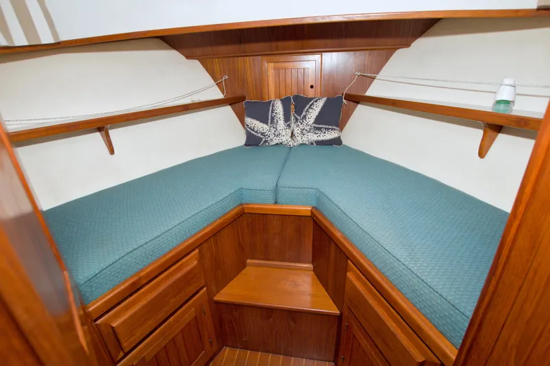 Slide: The Image of Cozy cabin interior of 1999 Monk 36 Trawler with teal bedding and wooden accents. - 39