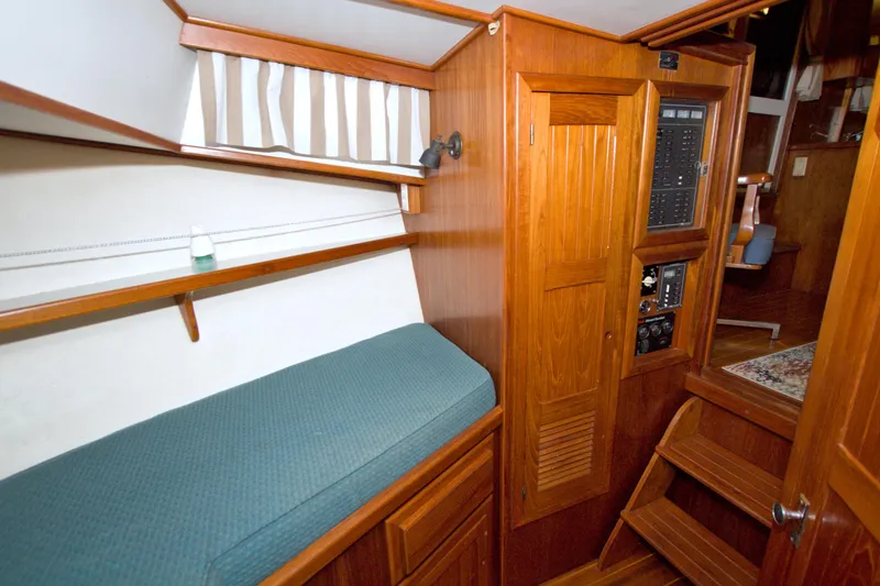 Slide: The Image of Interior of 1999 Monk 36 Trawler with wooden cabinetry and green cushioned seating. - 40