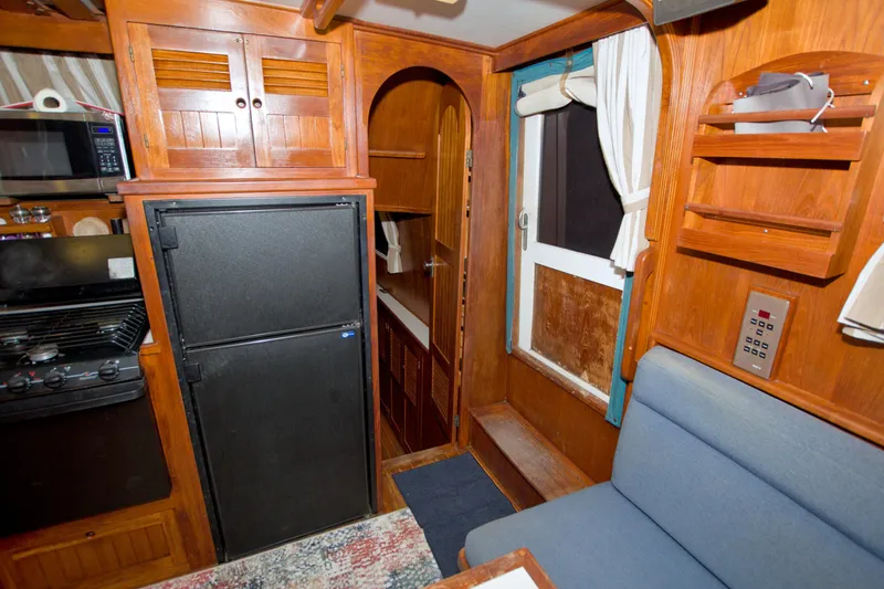 Slide: The Image of Interior of a 1999 Monk 36 Trawler with wooden cabinetry and seating area. - 44