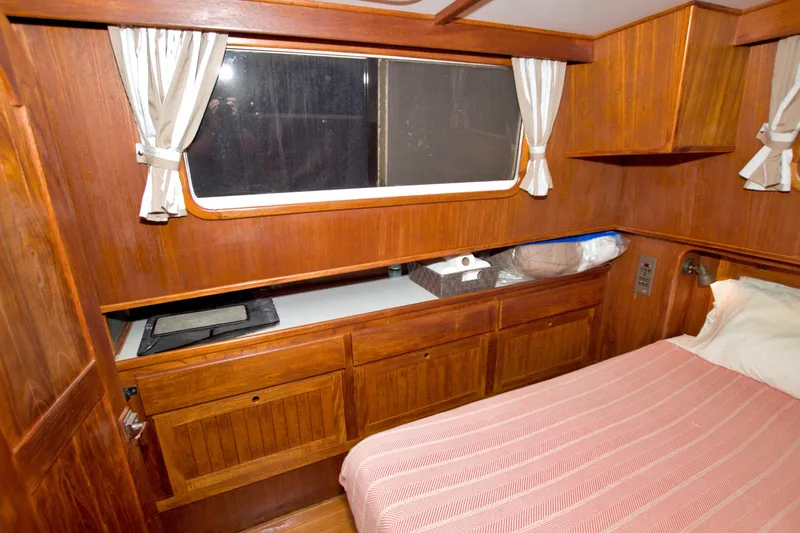 Slide: The Image of Cozy cabin interior of 1999 Monk 36 Trawler with wooden finish and window curtains. - 49
