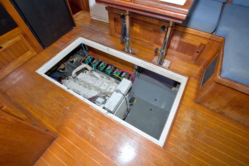 Slide: The Image of Engine compartment of a 1999 Monk 36 Trawler with visible machinery and wooden flooring. - 55