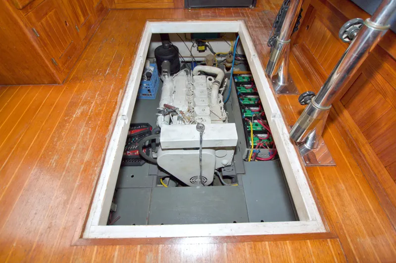 Slide: The Image of Engine compartment of a 1999 Monk 36 Trawler, showcasing the engine and battery setup. - 56