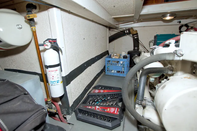 Slide: The Image of Engine room of a 1999 Monk 36 Trawler with tools and fire extinguisher. - 58