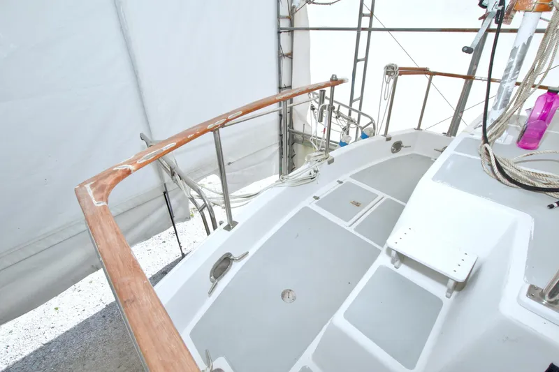 Slide: The Image of 1999 Monk 36 Trawler deck with wooden railings and ropes in a covered area. - 7