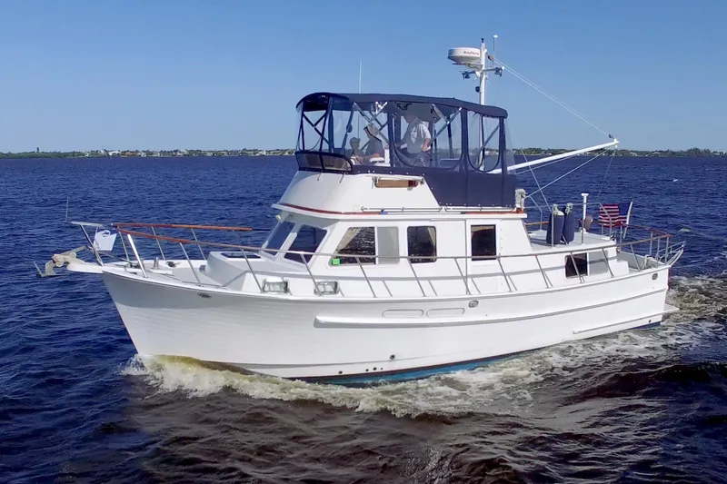 Slide: The Image of 1999 Monk 36 Trawler cruising on open water under clear blue skies. - 78