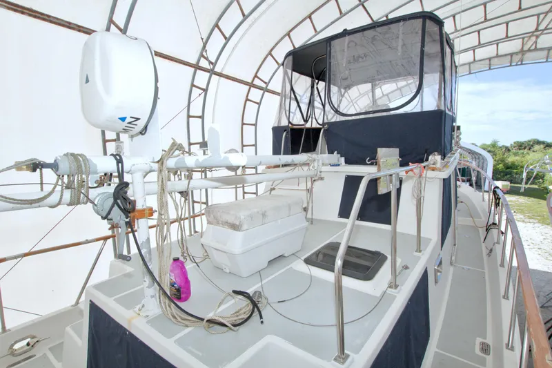 Slide: The Image of 1999 Monk 36 Trawler boat deck under canopy, featuring ropes and equipment. - 9