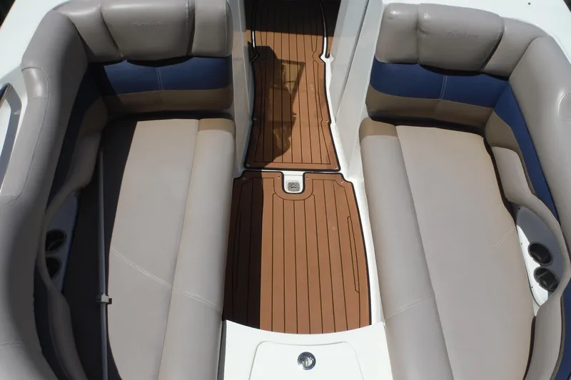 Slide: The Image of 2018 Hurricane SunDeck 2690 OB boat interior with cushioned seating and wooden flooring. - 10