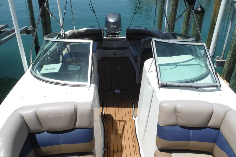 Slide: The Image of 2018 Hurricane SunDeck 2690 OB boat interior with seating and open windshield. - 11