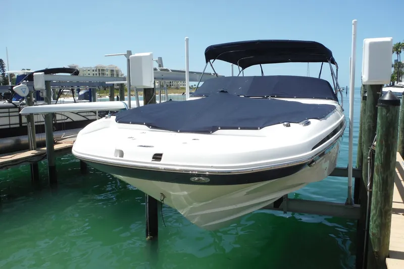Slide: The Image of 2018 Hurricane SunDeck 2690 OB boat docked with cover, in a marina setting. - 32