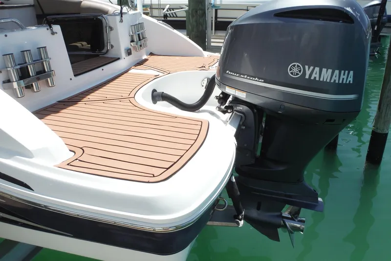 Slide: The Image of 2018 Hurricane SunDeck 2690 OB with Yamaha outboard motor, docked on turquoise water. - 5