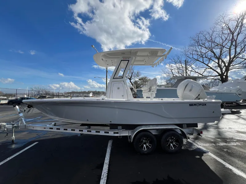 Slide: The Image of 2024 Sea Fox 231 Bay Fox boat on a trailer under a clear blue sky. - 14