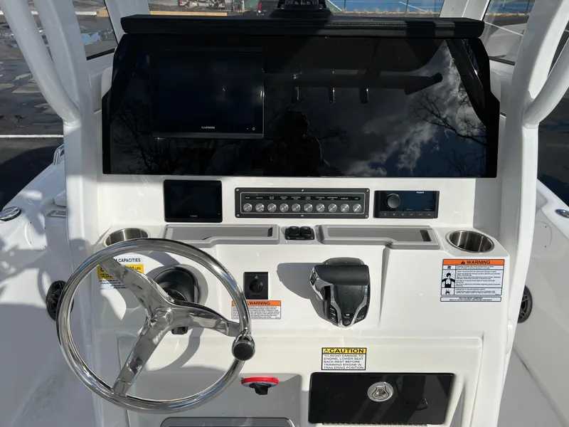 Slide: The Image of 2024 Sea Fox 231 Bay Fox boat console with steering wheel and electronic controls. - 16