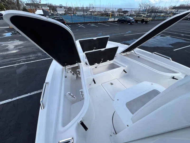 Slide: The Image of 2024 Sea Fox 231 Bay Fox boat with open storage compartments in a parking lot. - 26