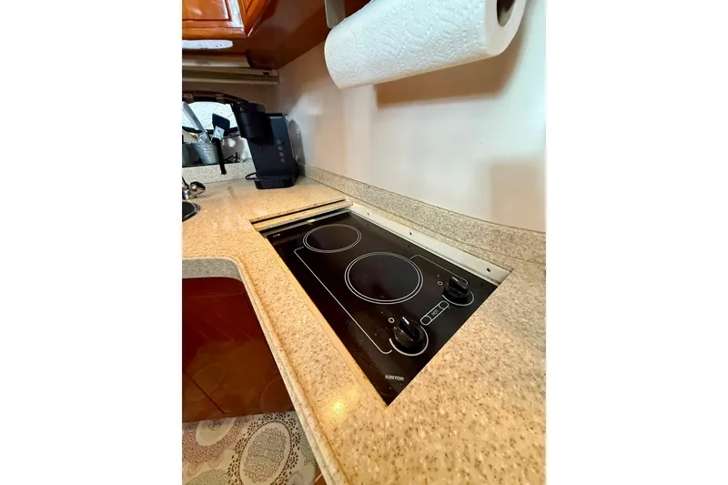 Slide: The Image of 2006 Regal Commodore 4060 yacht kitchen with electric stovetop and coffee maker. - 19