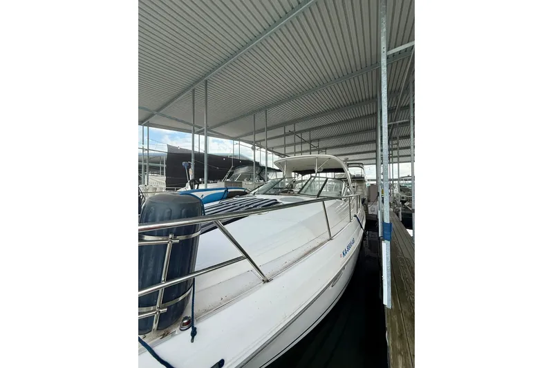 Slide: The Image of 2006 Regal Commodore 4060 yacht docked under a covered marina. - 2