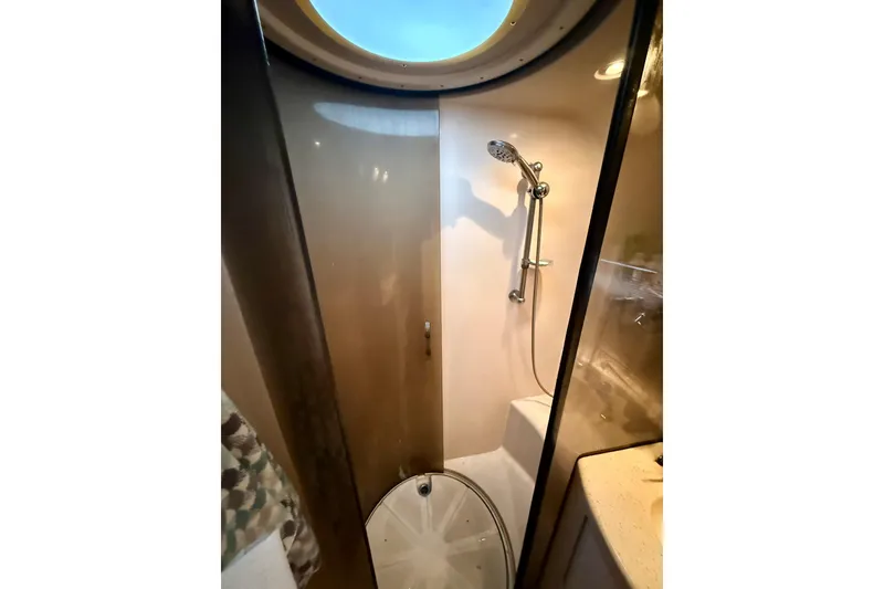Slide: The Image of Shower area in 2006 Regal Commodore 4060 yacht with circular window and modern fixtures. - 26