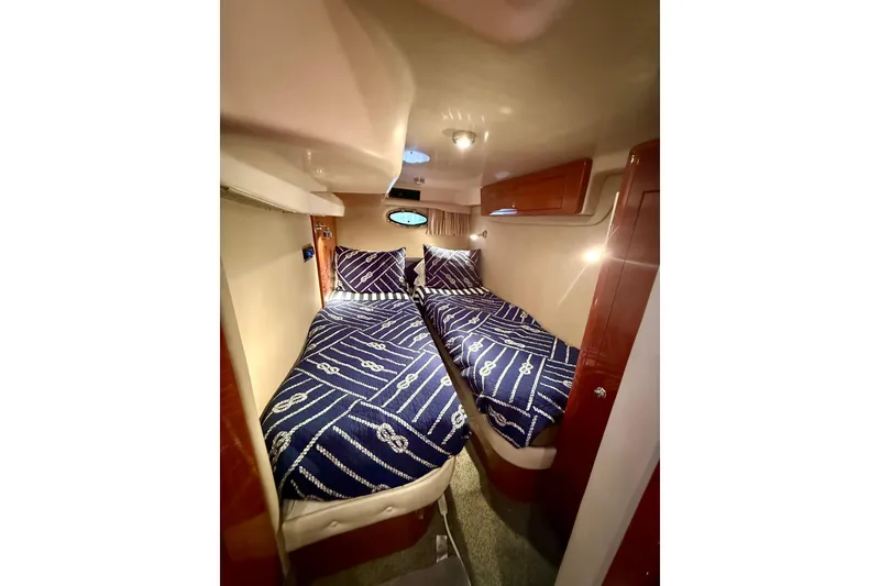 Slide: The Image of 2006 Regal Commodore 4060 cabin with twin beds and nautical-themed bedding. - 29