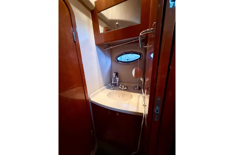 Slide: The Image of Bathroom interior of 2006 Regal Commodore 4060 yacht with wooden cabinetry and oval window. - 30