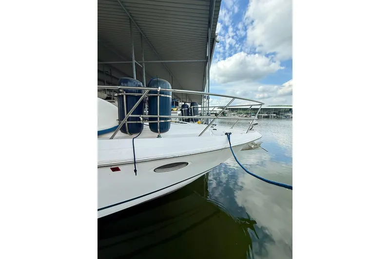 Slide: The Image of 2006 Regal Commodore 4060 yacht docked under a covered marina with blue skies. - 7
