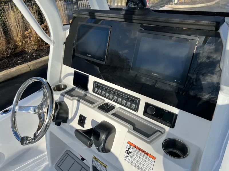 Slide: The Image of 2024 Sea Fox 251 Bay Fox boat dashboard with dual screens and steering wheel. - 11