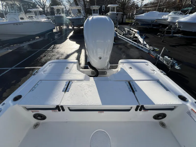 Slide: The Image of 2024 Sea Fox 251 Bay Fox boat with outboard motor, docked among other boats. - 13