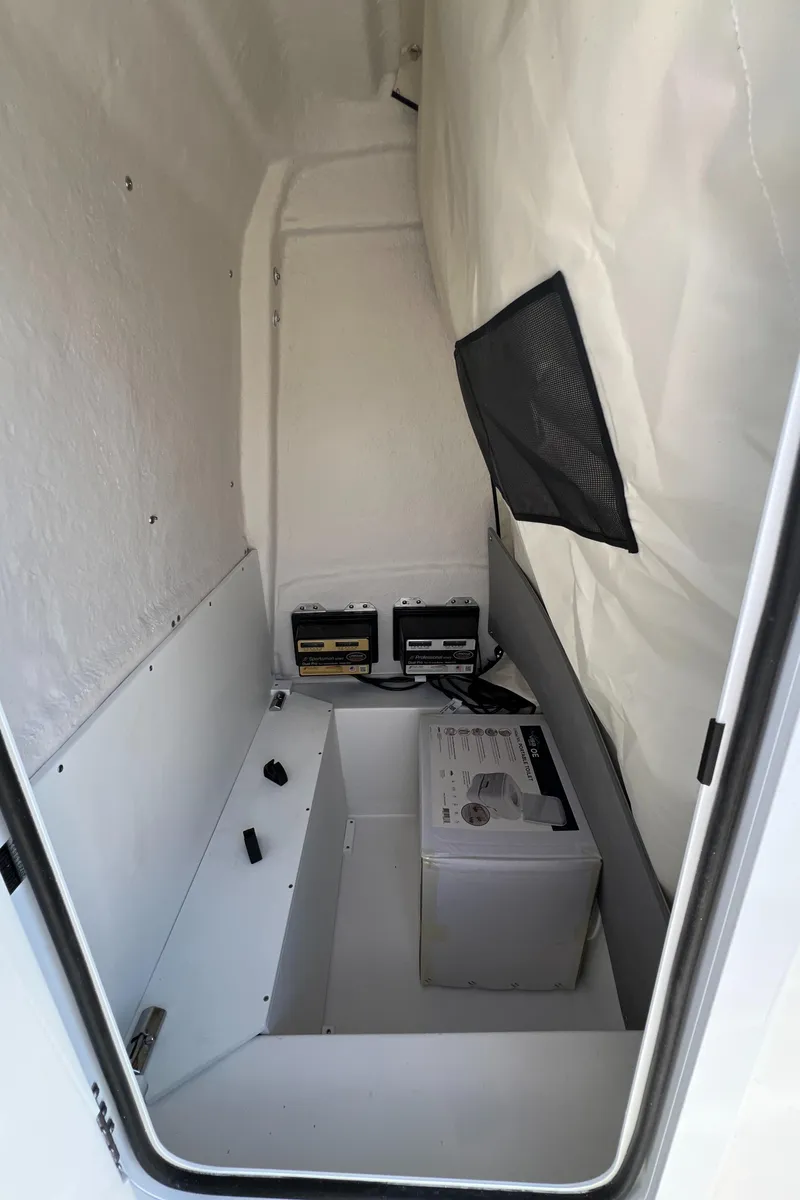 Slide: The Image of 2024 Sea Fox 251 Bay Fox interior storage compartment with battery setup. - 9