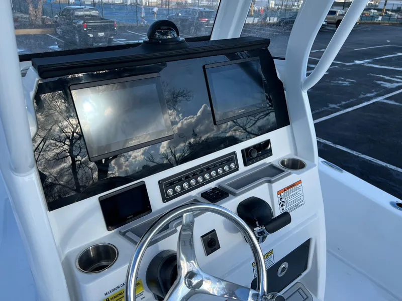 Slide: The Image of 2024 Sea Fox 251 Bay Fox dashboard with dual screens and steering wheel. - 10