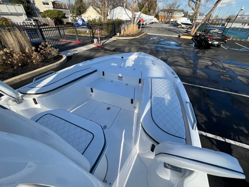 Slide: The Image of 2024 Sea Fox 251 Bay Fox boat with spacious seating and sleek design in a parking lot. - 6