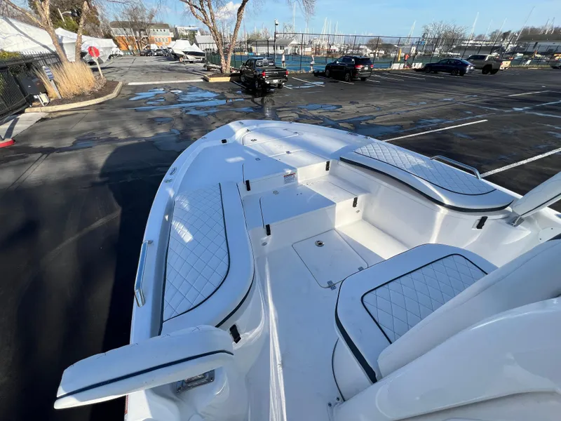 Slide: The Image of 2024 Sea Fox 251 Bay Fox boat with spacious seating in a marina parking lot. - 7