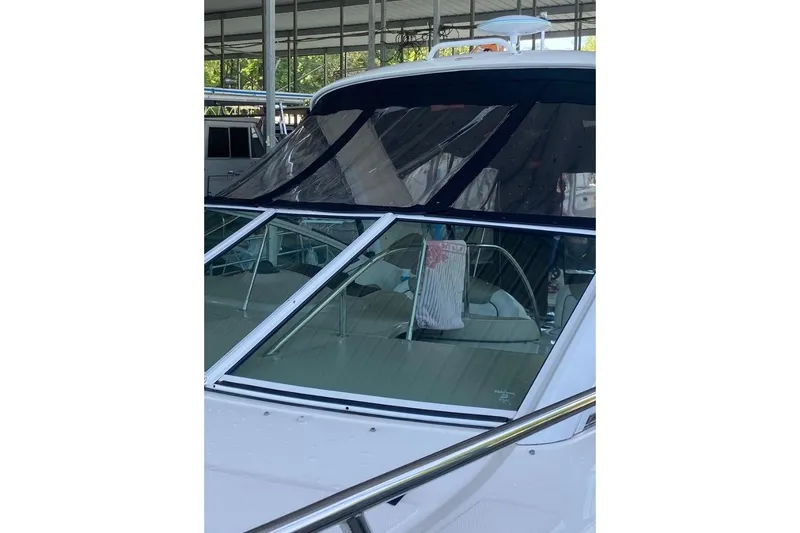 Slide: The Image of 2006 Sea Ray 290 Sundancer boat with covered cockpit, docked under shelter. - 13