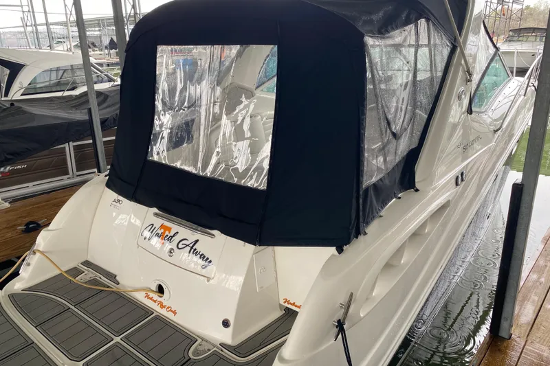 Slide: The Image of 2006 Sea Ray 290 Sundancer boat docked with black canopy and clear windows. - 15