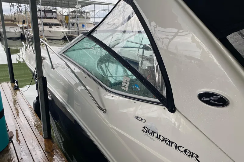 Slide: The Image of 2006 Sea Ray 290 Sundancer docked in a marina, showcasing sleek design and branding. - 18