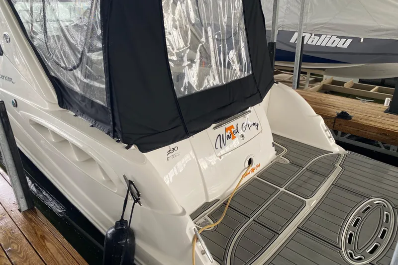 Slide: The Image of 2006 Sea Ray 290 Sundancer docked, featuring a covered cockpit and swim platform. - 20