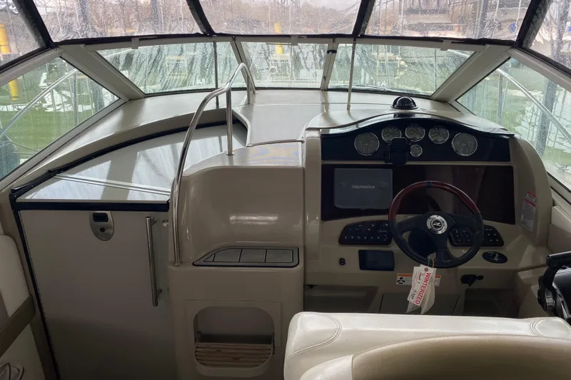 Slide: The Image of 2006 Sea Ray 290 Sundancer boat cockpit with steering wheel and instrument panel. - 25