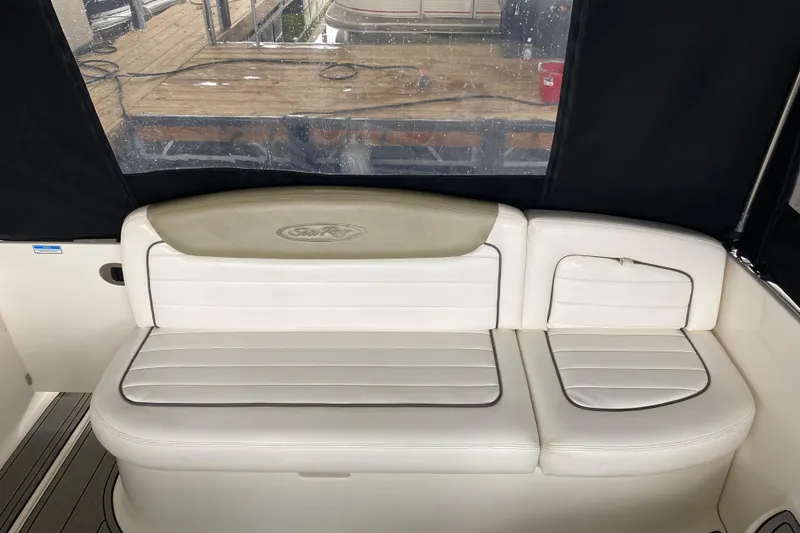 Slide: The Image of 2006 Sea Ray 290 Sundancer boat interior with white cushioned seating. - 27