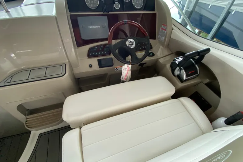 Slide: The Image of 2006 Sea Ray 290 Sundancer helm with steering wheel and control panel. - 28