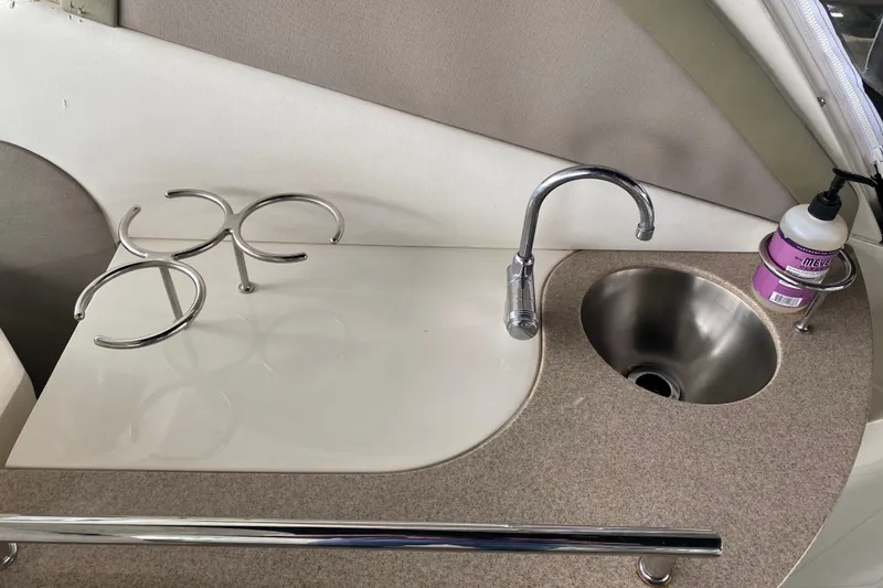 Slide: The Image of 2006 Sea Ray 290 Sundancer kitchenette with sink, faucet, and cup holders. - 30