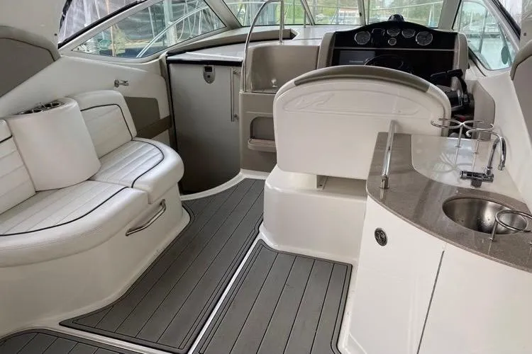 Slide: The Image of 2006 Sea Ray 290 Sundancer interior with seating, helm, and kitchenette. - 34
