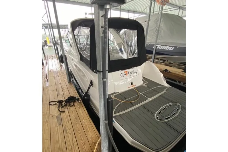 Slide: The Image of 2006 Sea Ray 290 Sundancer docked, featuring a covered cockpit and swim platform. - 8